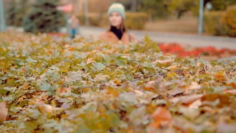 Mädchen-hält-ihre-Hand-über-den-Busch-im-Herbst-park