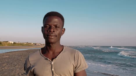 serious-confident-lonely--black-african-man-walking-on-the-beach-looking-camera