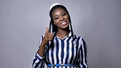 happy-african-smiling-girl-showing-OK-sigh-at-camera-while-standing-ovet-gray-background