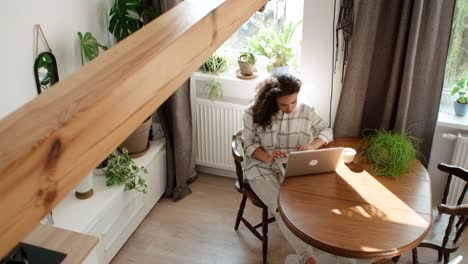 Charmante-junge-Frau,-die-Eingabe-auf-Laptop-Computer-zu-Hause.