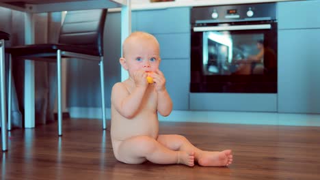 Niedlichen-nackten-Baby-sitzen-auf-dem-Boden-in-der-Wohnung