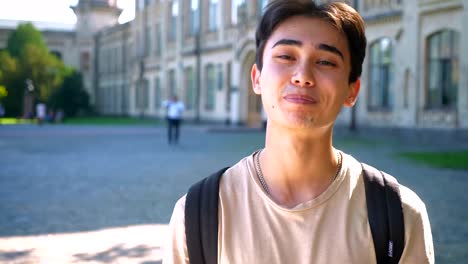 Happy-asian-boy-man-smiles-in-braces-while-standing-in-the-middle-of-the-empty-street,-urban-area,-sunlights