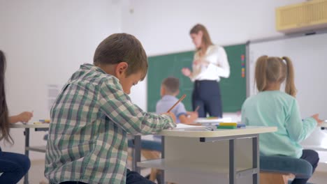 Porträt-von-glücklichen-Schulkind-am-Schalter-während-der-Schulzeit-Unterricht-im-Klassenzimmer-an-Junior-School-hautnah