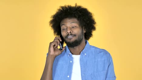 Afro-American-Man-Talking-on-Smartphone-on-Yellow-Background