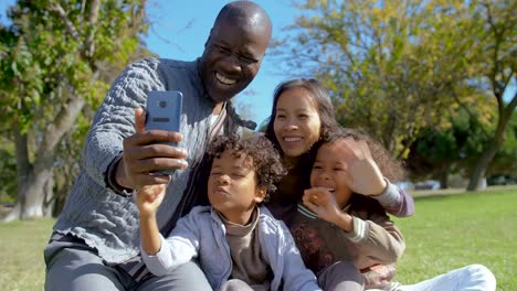 Multicultural-family-waving,-blowing-air-kisses-and-having-video-chat