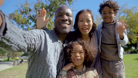 Multicultural-parents-and-children-waving-and-making-video-call