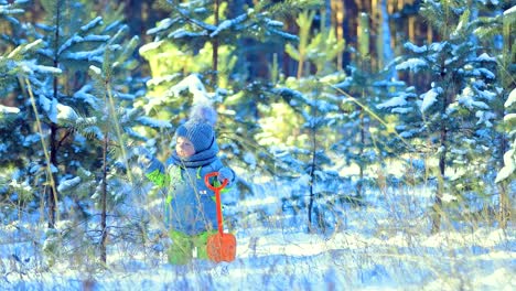 Kind-schüttelt-den-Schnee-vom-Baum.-Kind-hält-einen-Spaten.-Wintertag