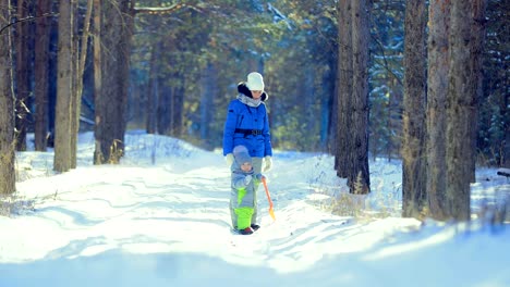 Niño-con-su-madre-camina-en-el-bosque-de-invierno.-Día-claro-escarchado.-Niño-sosteniendo-una-espada.-Ir-en-el-camino