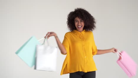 African-american-woman-walking-and-spinning-while-carrying-shopping-bags