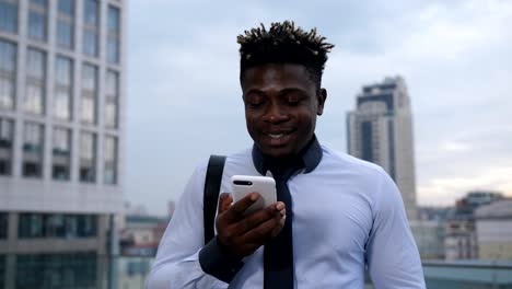 Dark-skinned-businessman-chatting-online-on-phone