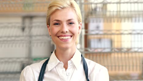 Happy-server-smiling-at-camera-beside-her-cupcakes