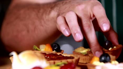 Close-up-hands-tidying-the-pastries