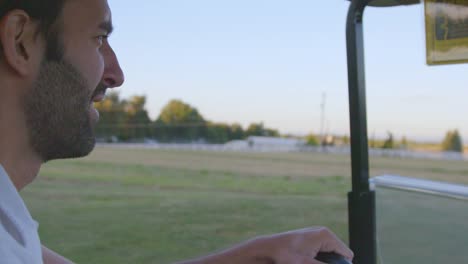 Man-smiles-driving-golf-cart