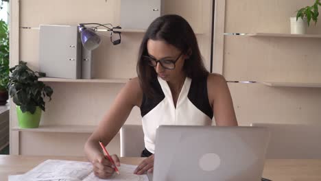 Trabajo-de-la-mujer-adulta-con-laptop-sentada-en-el-escritorio