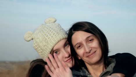 Portrait-of-happy-mother-and-teenage-daughter-smiling,-hugging,-showing-love,-waving-hands-footage.