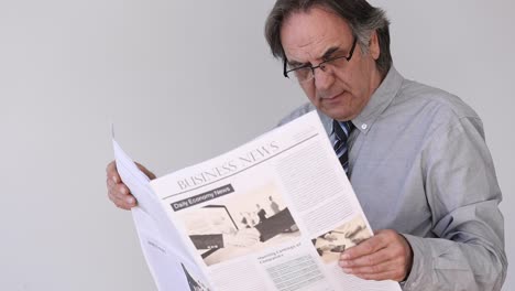 Senior-man-reading-newspaper-on-gray-background