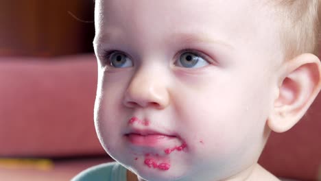 An-attractive-boy-2-years-old-eats-a-red-beet-salad.-The-face-is-smeared-with-porridge.-Sits-on-the-table.-Close-up