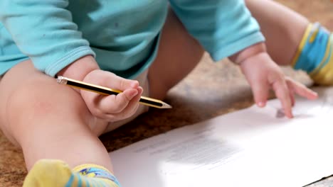 An-attractive-boy-draws-a-pencil-on-a-book-for-2-years.-Home-decor.-Blue-T-shirt