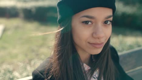 Joven-hermosa-mujer-afroamericana-sentada-en-un-banco.