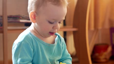 Attractive-boy-2-years-of-playing-at-home-with-a-plastic-duck.-The-kid-talks-to-his-parents.-Close-up