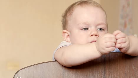 Süße-Blondine-zeigt-in-ein-Kinderbett-mit-einer-Schraube-zu-spielen.-Er-lächelt-und-dreht-es-in-seinen-Armen