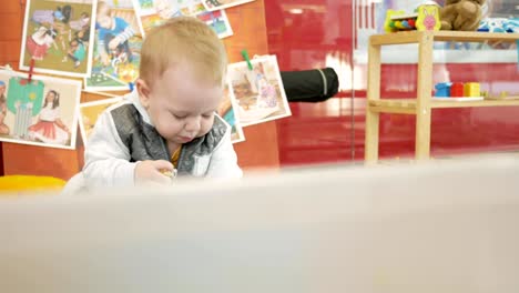 Cute-blond-babe-is-playing-with-toys-in-the-mall.-Children's-area-to-leave-children-when-shopping