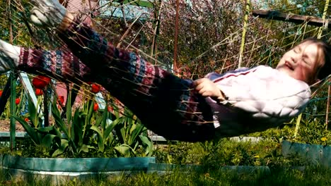 Baby-girl-playing-in-the-hammock-near-the-house