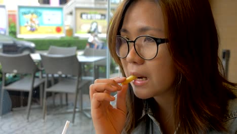 young-woman-eating-french-fries