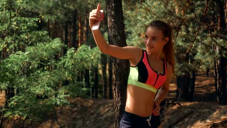 una-hermosa-atleta-hace-fotos-en-el-teléfono-en-el-bosque