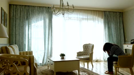 Upset-woman-going-forth-and-back-along-the-window-of-a-cozy-apartment