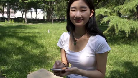 Asian-girls-use-mobile-phone-in-the-park