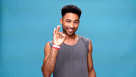 Young-happy-african-man-showing-okay-gesture-over-blue-background.