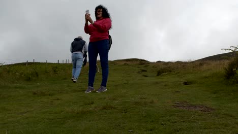 Cheerful-woman-taking-pictures-on-the-hill