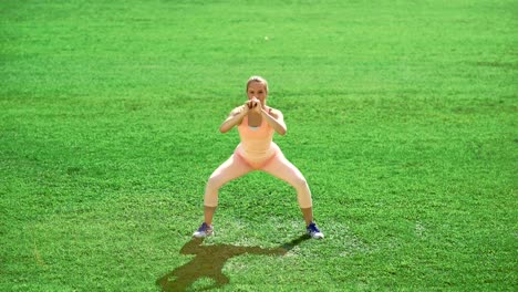 Slim-athletic-woman-doing-exercises-on-green-grass