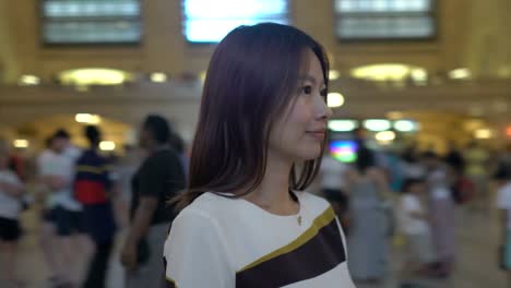 Attractive-Asian-Woman-Using-Phone-in-the-City.-Dark-Eyes-and-Dark-Hair.-Crowded-and-Urban-Background.