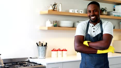 Smiling-man-standing-with-arms-crossed-in-kitchen