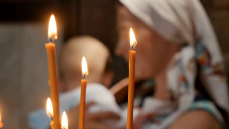 Porträt-der-jungen-Frau-mit-kleinen-Jungen-hinter-die-Kerzen-in-der-Kirche