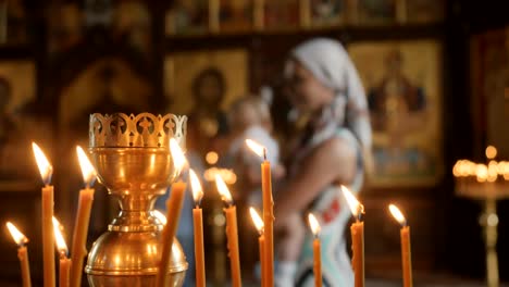 Junge-Mutter-mit-kleinen-Sohn-in-die-Arme-sind-in-der-Nähe-der-Ikonen-in-der-Kirche