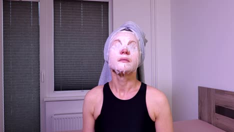 Women-with-facial-mask-on-the-face-sitting-on-bed