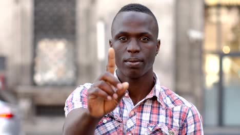 young-black-man-making-"no"-with-his-finger--outdoor