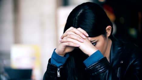 cerca-de-retrato-de-mujer-asiática-preocupada-y-triste,-sentado-en-el-bar-al-aire-libre