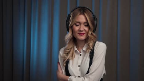 A-woman-is-sexually-flirting-with-the-camera-and-touching-her-hair-listening-to-music-in-big-headphones