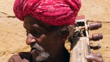 Indische-Senior-spielt-traditionelle-Musikinstrument-in-Jaisalmer-Fort,-Rajasthan,-Indien