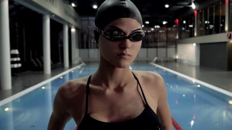 Gafas-de-nadador-de-mujer-en-hacer-ejercicio-estiramiento-para-natación-en-piscina-de-agua