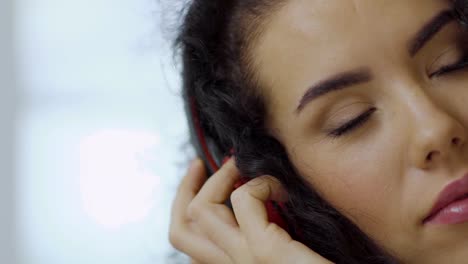 Curly-brunette-enjoy-of-listening-music-with-headphones