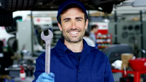 Portrait-of-a-young-beautiful-car-mechanic-in-a-car-workshop,-in-the-background-of-service.-Concept:-repair-of-machines,-fault-diagnosis,-repair-specialist,-technical-maintenance-and-on-board-computer