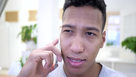 African-Young-Man-Talking-On-Smartphone