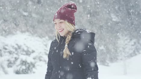 Schöne-junge-asiatische-Frau-wirft-Schnee-in-der-Luft-auf-einem-Wald