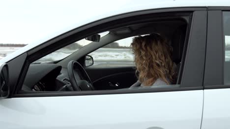 Young-woman-showing-key-to-new-car