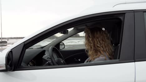 Closeup-portrait,-young-cheerful,-joyful,-smiling,-woman-holding-up-keys-to-her-first-new-car.-Customer-satisfaction